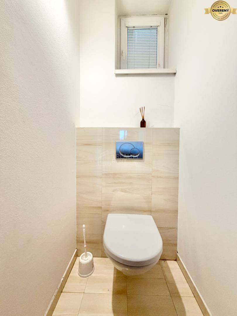 Toaleta so zavesenou misou v 3-izbovom byte, podlaha s dreveným dekorom.