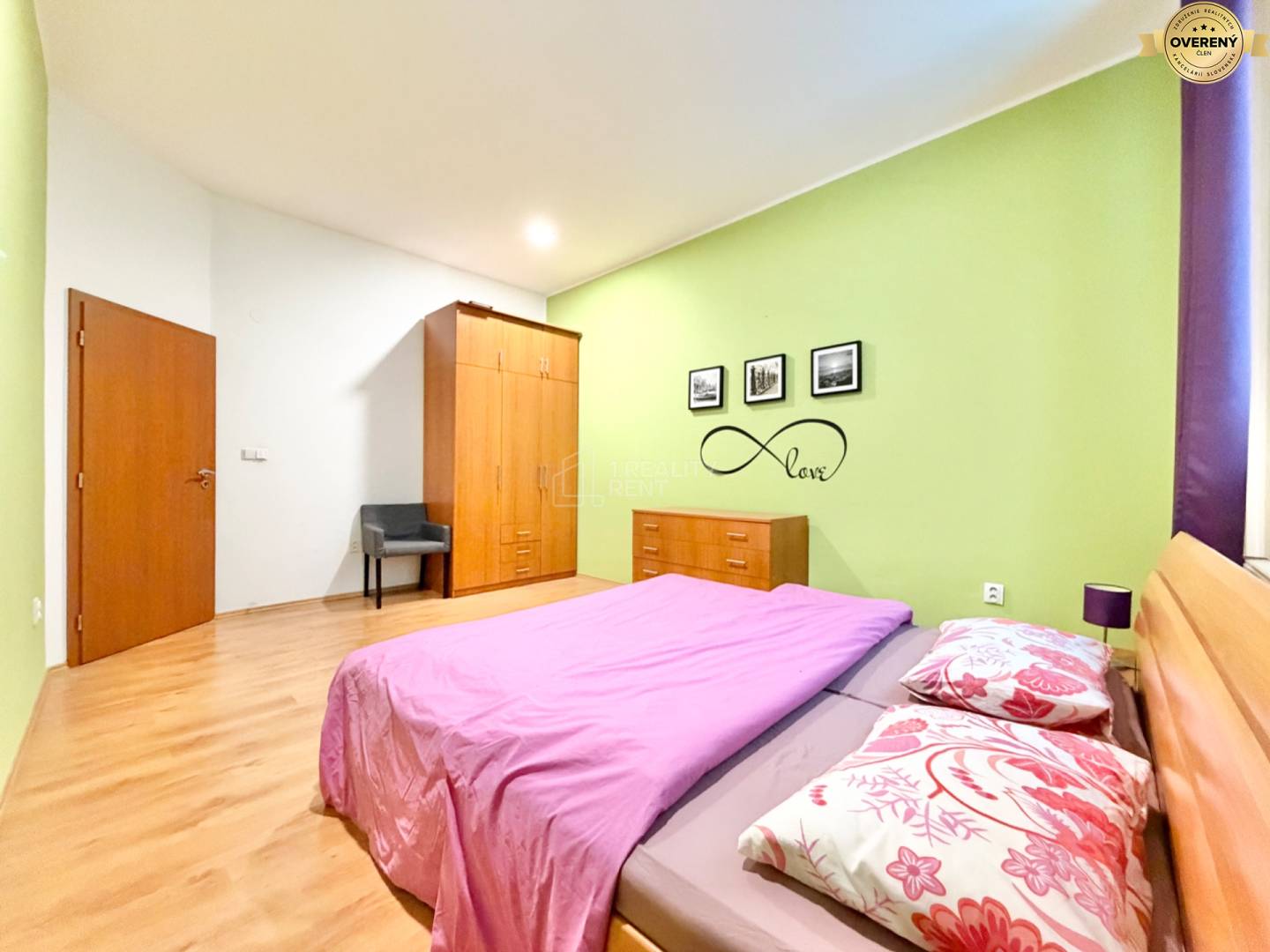 Spálňa v 3-izbovom byte s podlahou s dreveným dekorom a zelenou stenou.