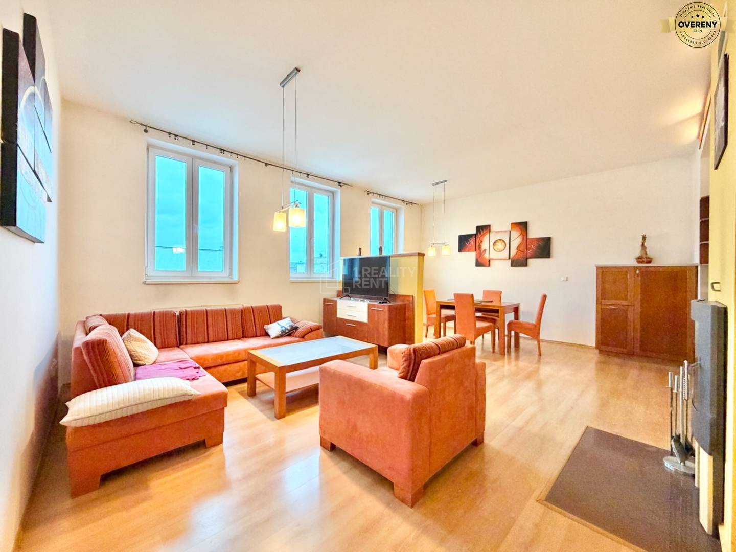 Obývacia izba v 3-izbovom byte s podlahou s dreveným dekorom a pohodlnou sedacou súpravou.