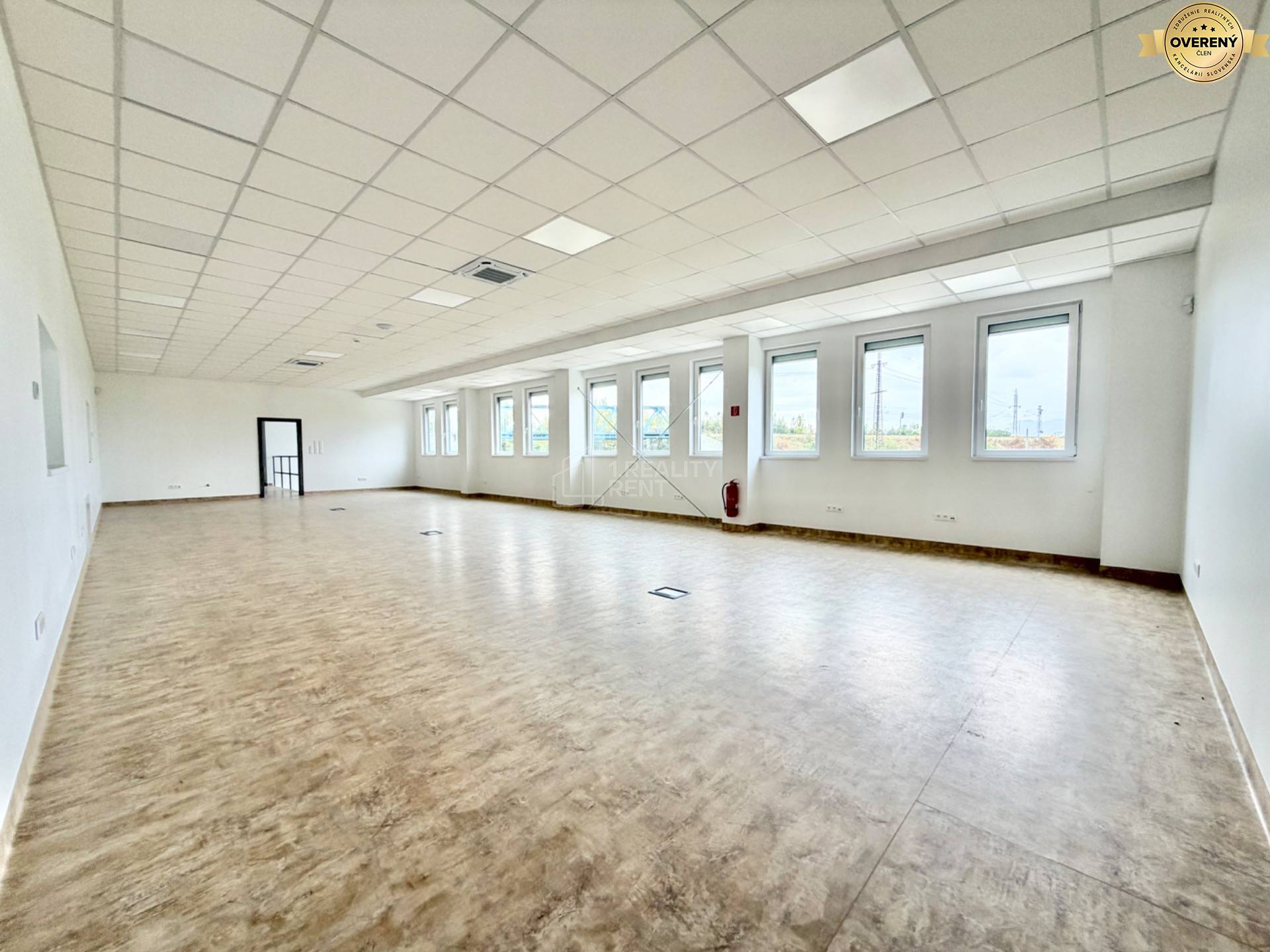 Priestranné kancelárie s podlahou s dreveným dekorom a veľkými oknami.