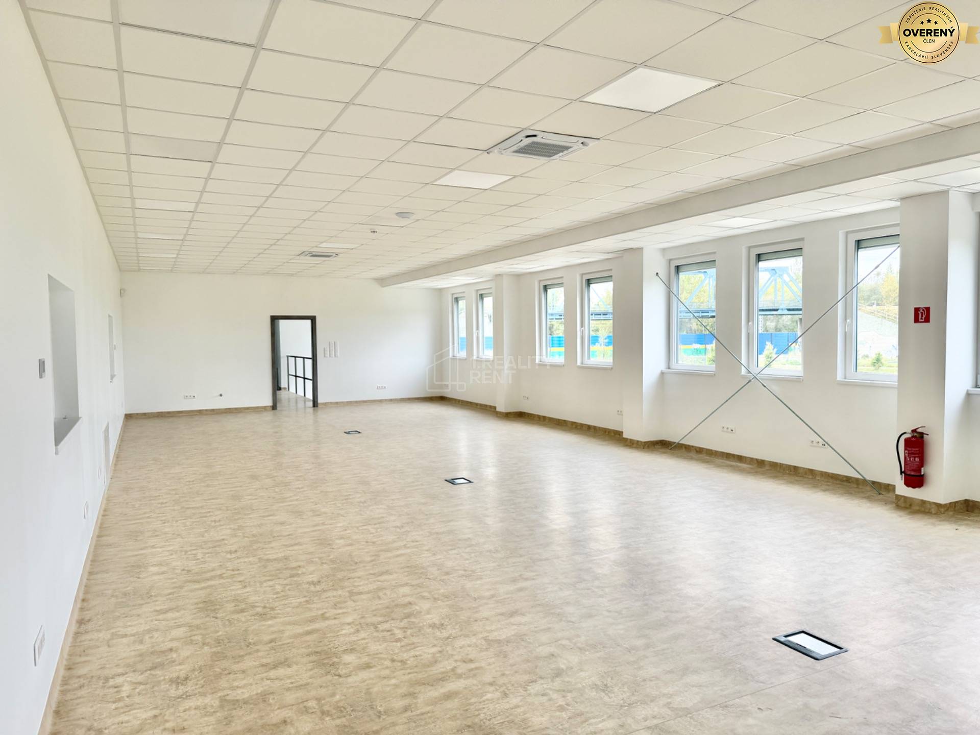 Priestranné kancelárie s oknami a podlahou s dreveným dekorom.