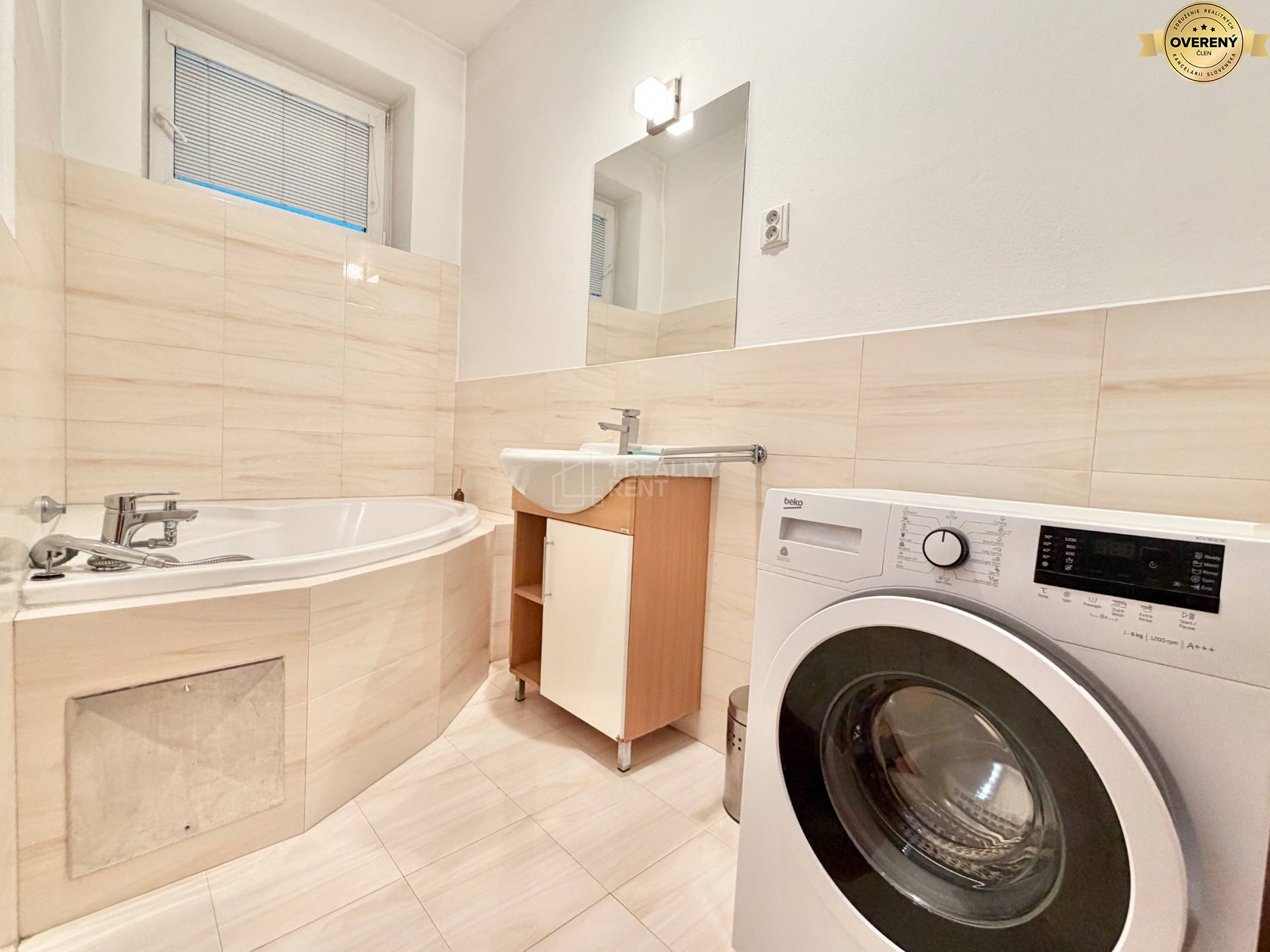 Kúpeľňa v 3-izbovom byte s vaňou, práčkou a umývadlom.