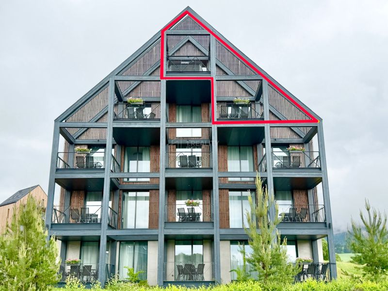 Exteriér rekreačného apartmánu v Demänovej s terasou a presklenou fasádou.