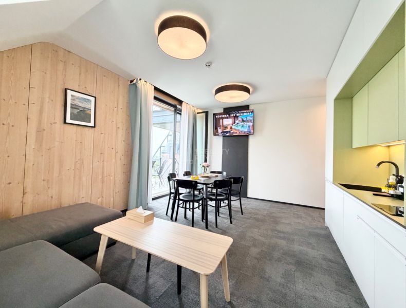 Rekreačný apartmán ponúka útulný priestor s posedením, jedálenským stolom a kuchynkou.