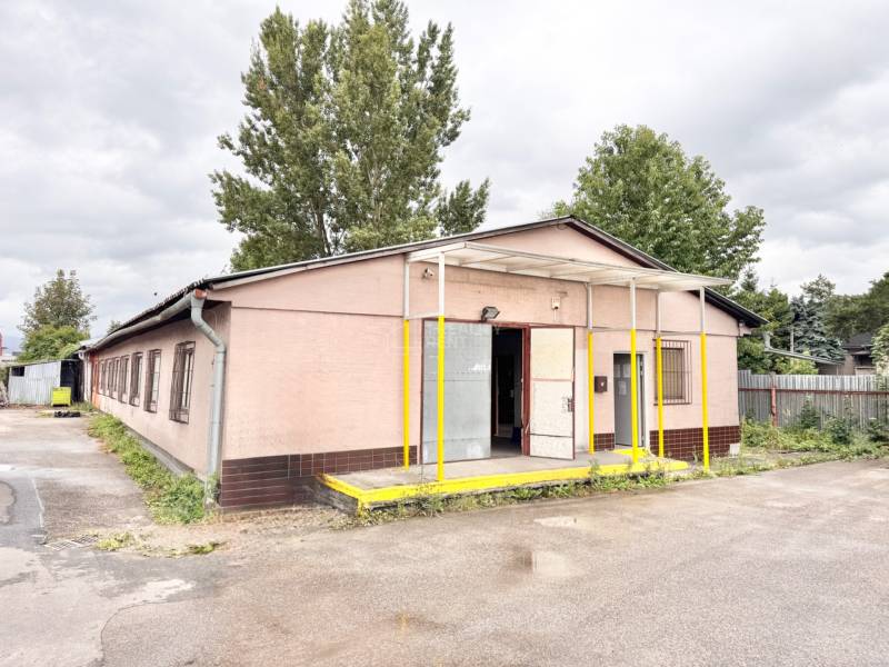 Budova na Bratislavskej ulici v Žiline, Sklady a haly, obklopená stromami.