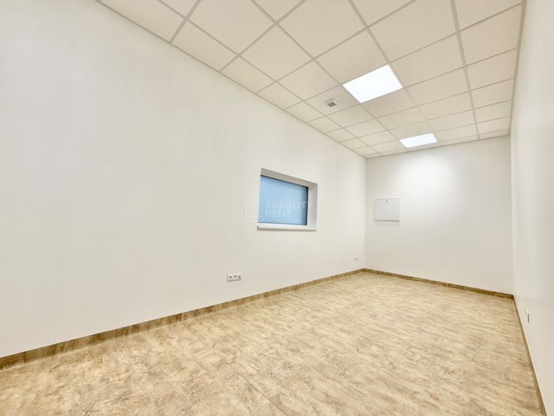 Biela kancelária s podlahou s dreveným dekorom, svetlý interiér, podhľad s osvetlením.