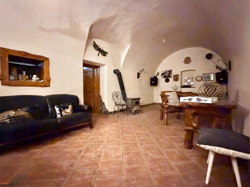 Obývacia izba v rodinnom dome s pohovkou a pecou, zdobená dreveným nábytkom.