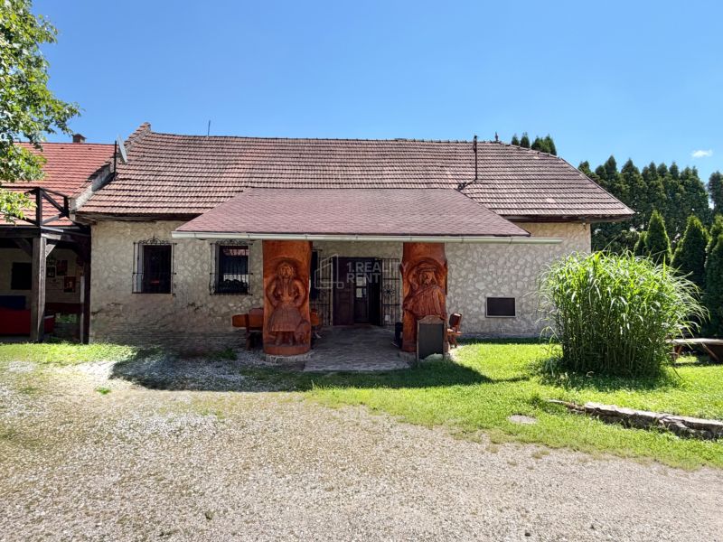 Rodinný dom v Belej-Duliciach na ulici Belá s kamennou fasádou a sochami pri vchode.